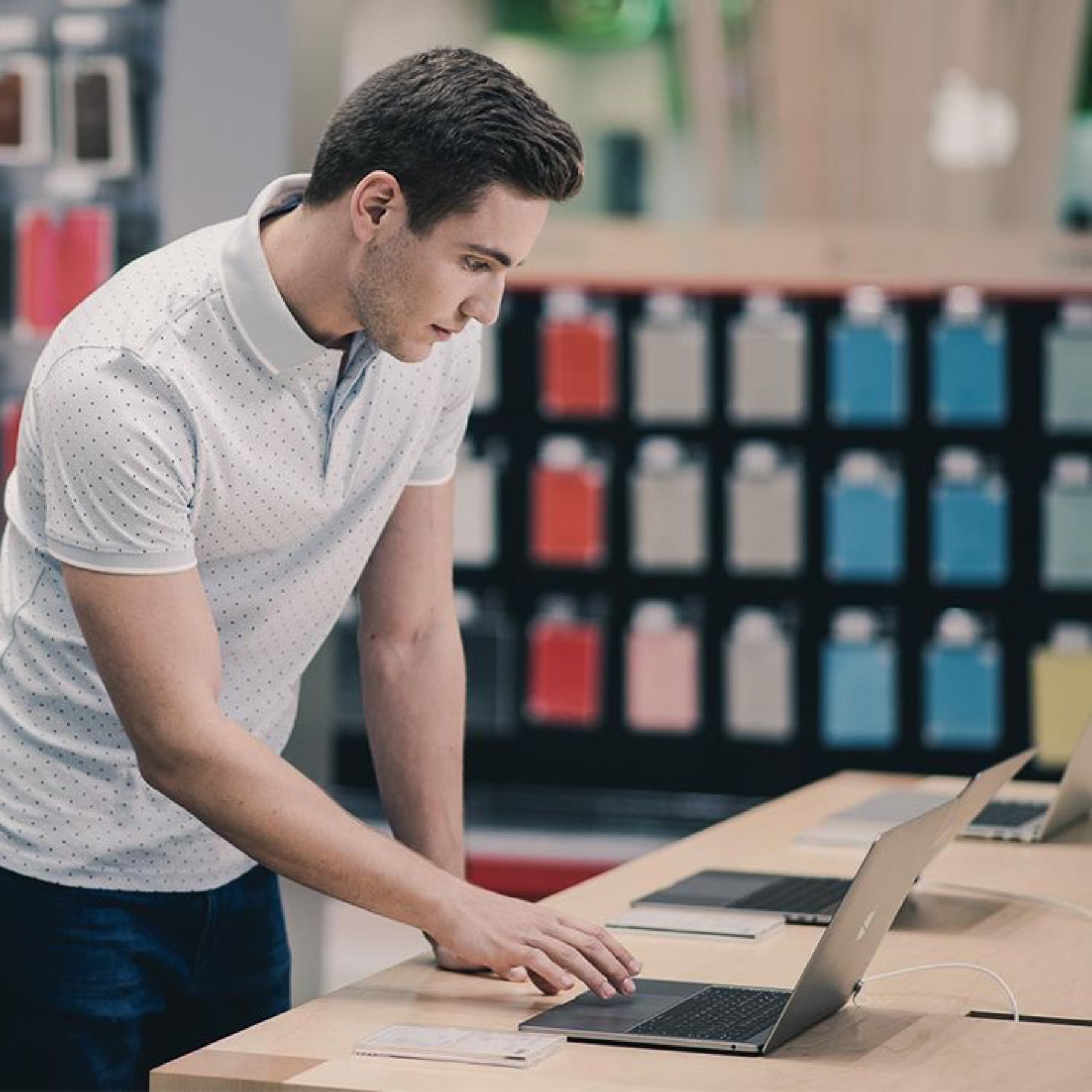 Shopper exploring laptops at an electronics display
