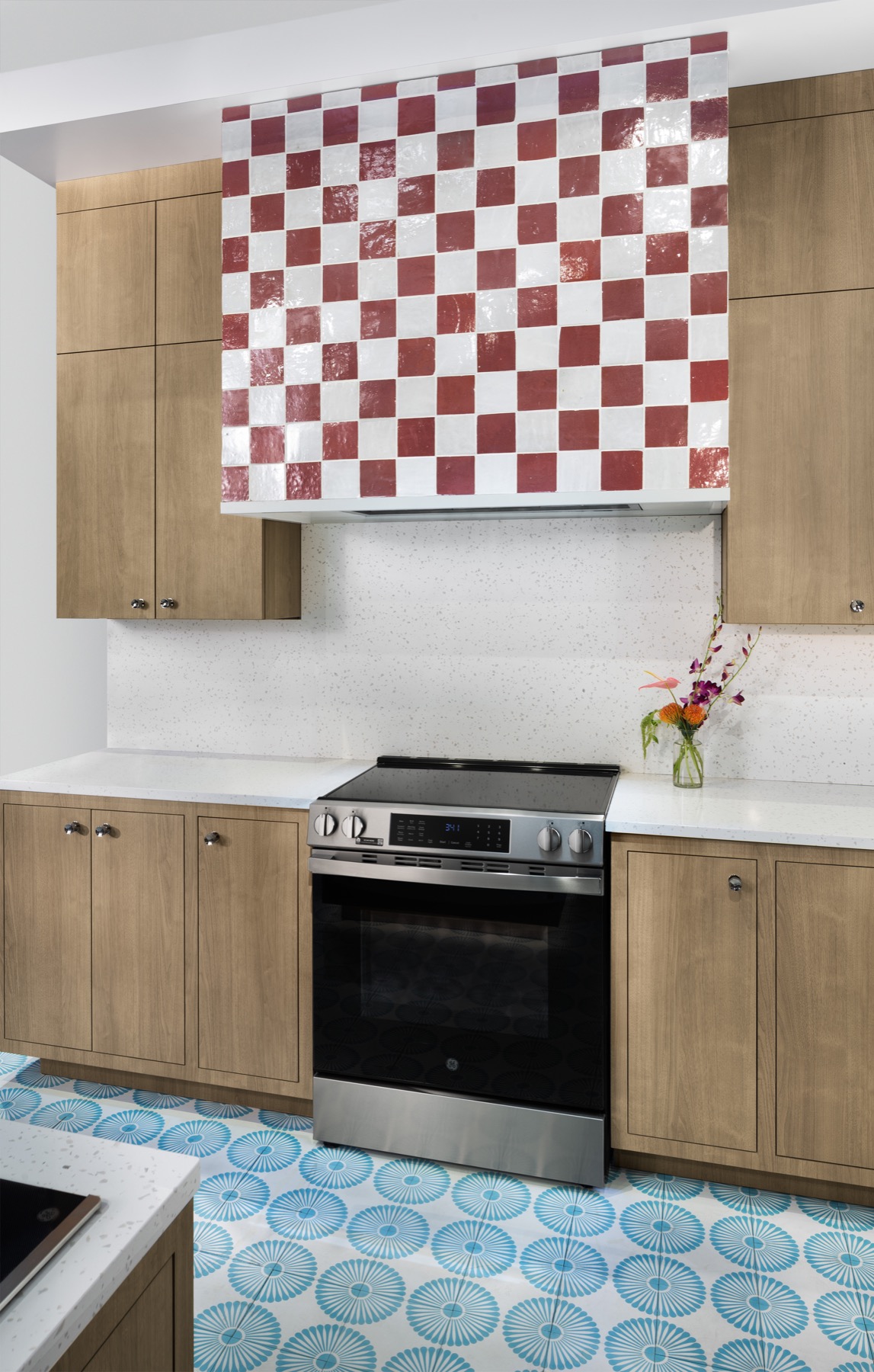 GE electric range in a contemporary kitchen with timber cabinets and patterned tiles