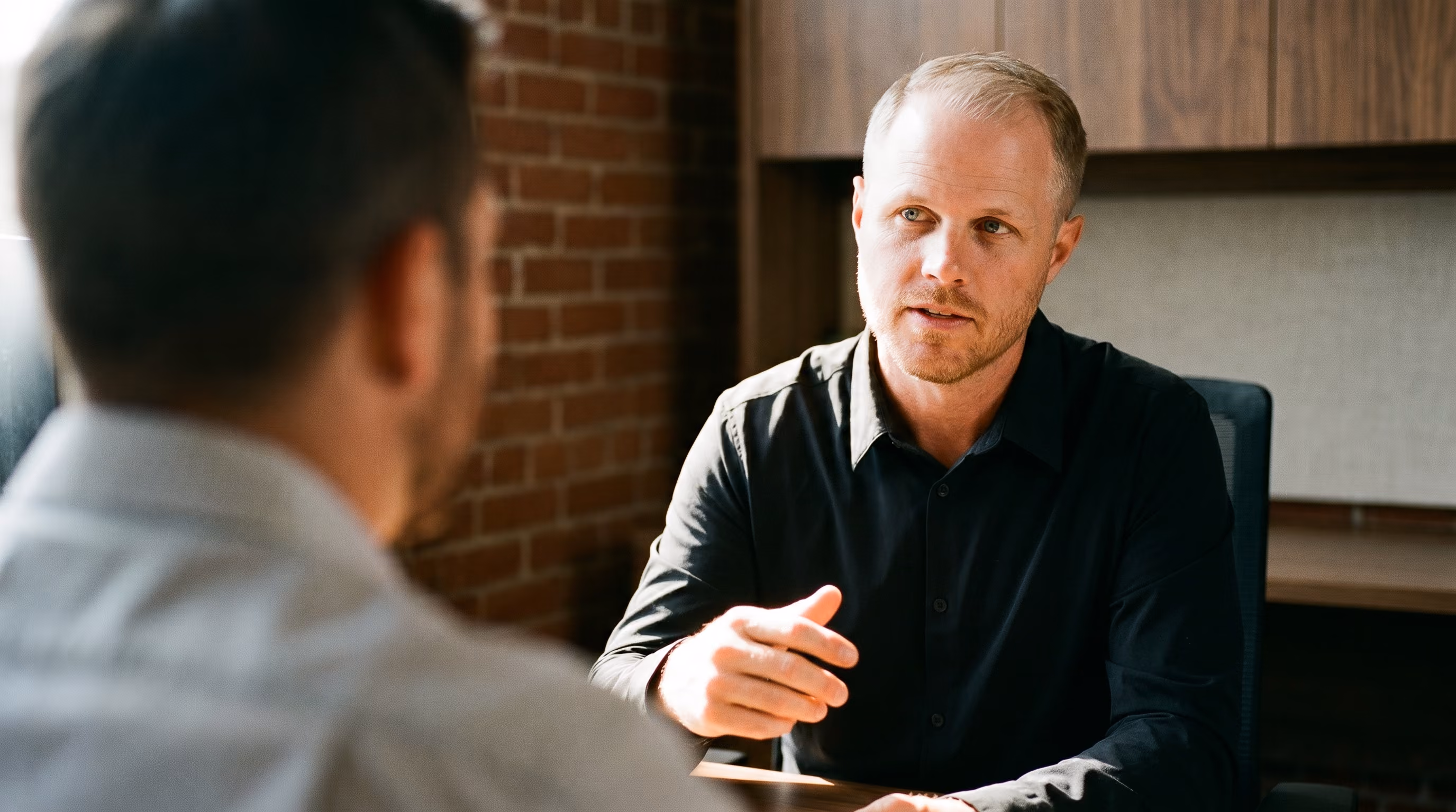 Blake, a KEPM consultant, talking with a coworker across a table