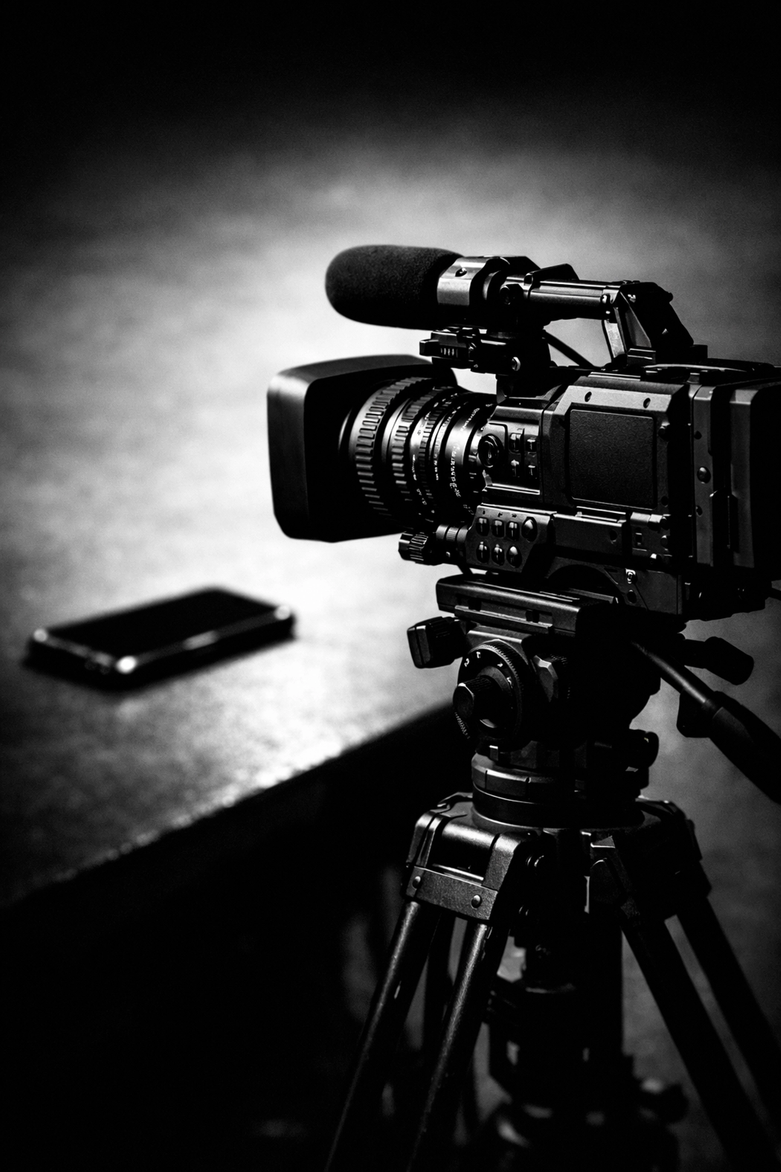 Professional video camera on tripod compared to smartphone for brand video production