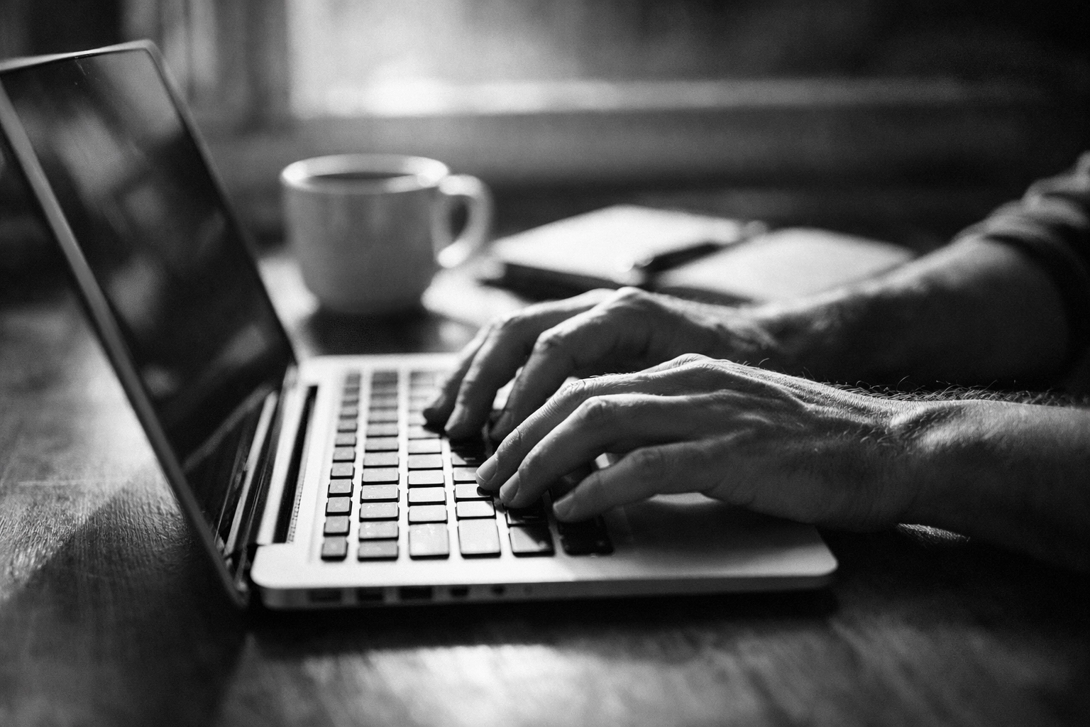 Content creator writing newsletter on laptop with coffee for email marketing strategy