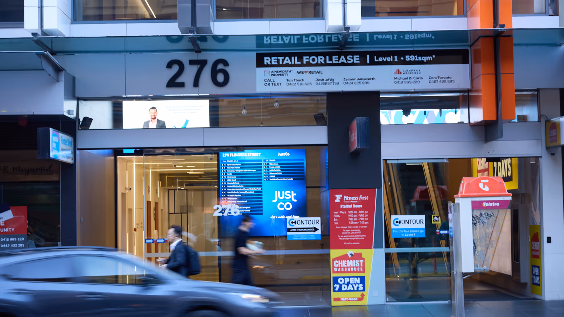 Street view of commercial building entrance at 276 with retail for lease signage and blurred pedestrians walking by.