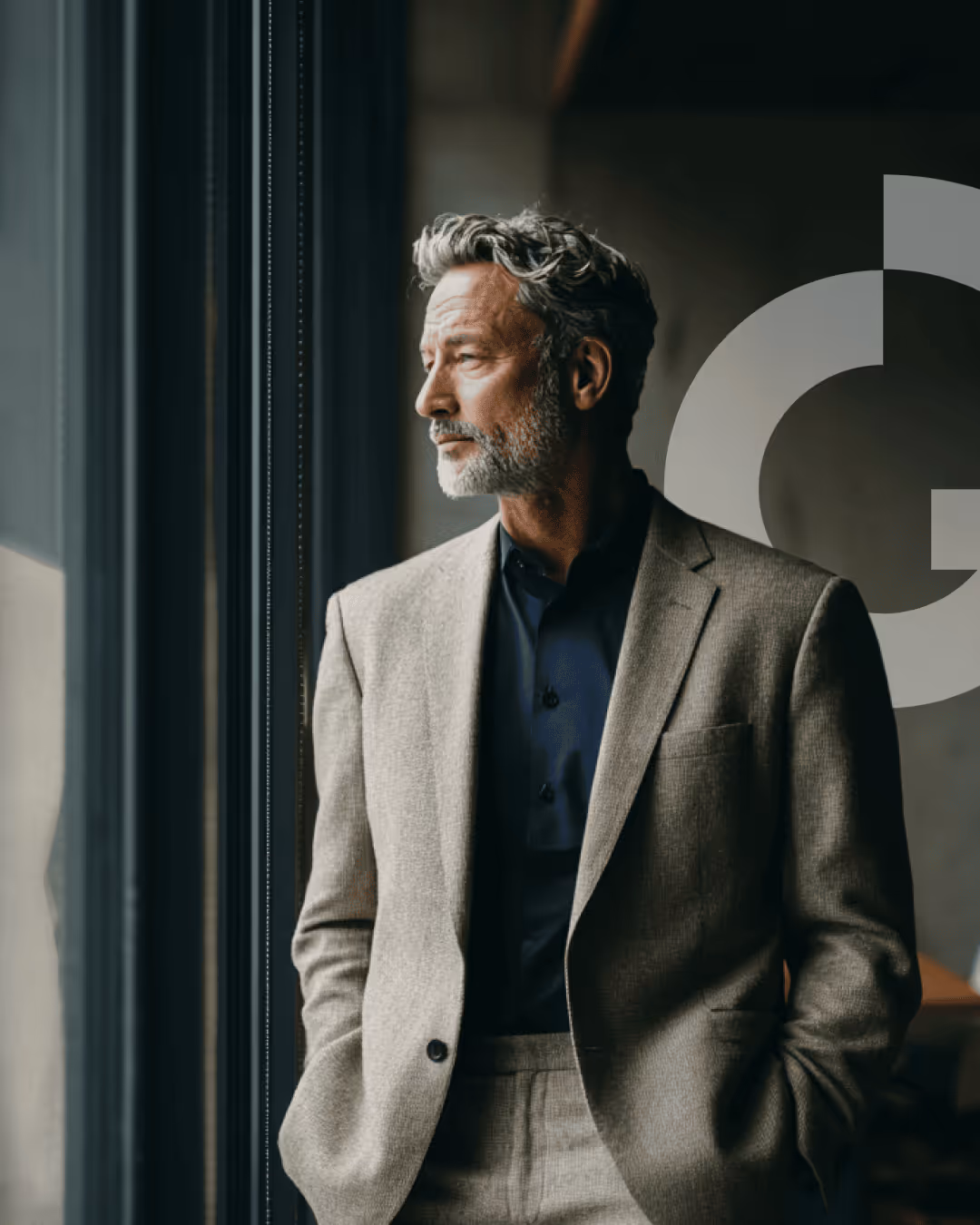 A distinguished executive stands at a floor-to-ceiling window, looking out with quiet confidence — representing the caliber of individual Richter Guardian is built to protect.