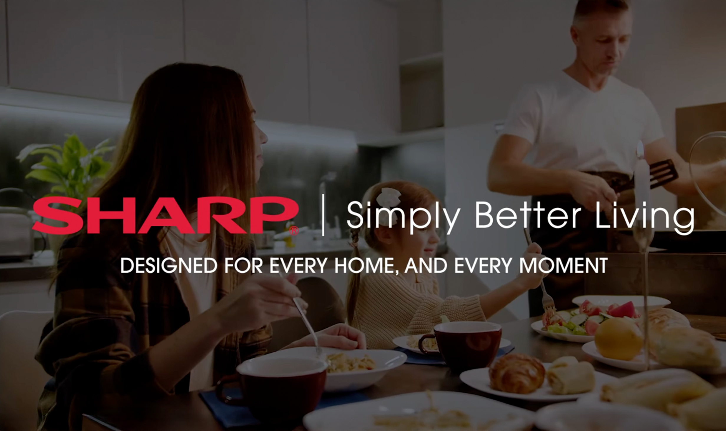 Family having breakfast in a kitchen with a man cooking and the Sharp logo with the slogan 'Simply Better Living' and 'Designed for every home, and every moment.'