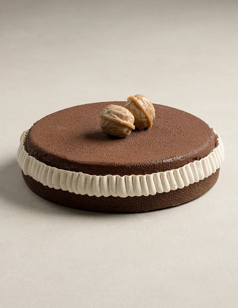 Whole Nut Noir cake with chocolate almond tart base, chocolate velvet finish, and praline walnuts.
