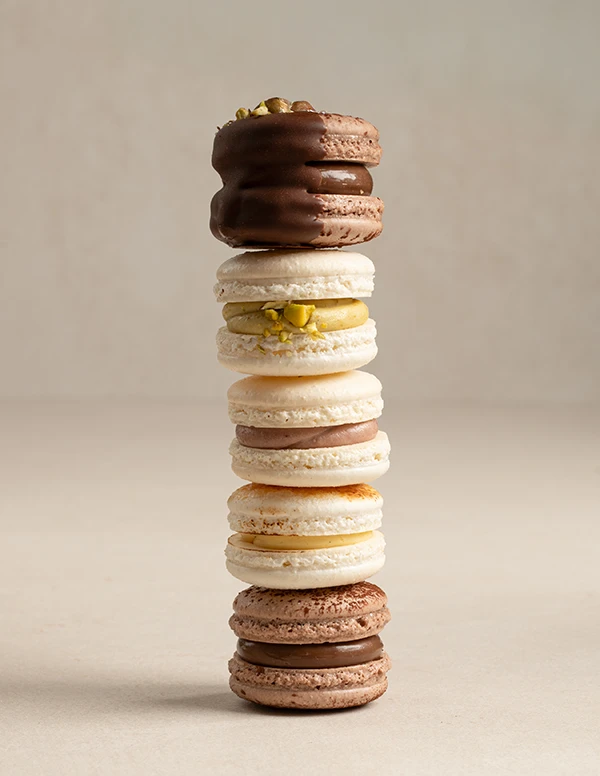 Assorted natural macarons from VANIL in pistachio, chocolate, crème brûlée, mixed berry, and Dubai chocolate flavors.