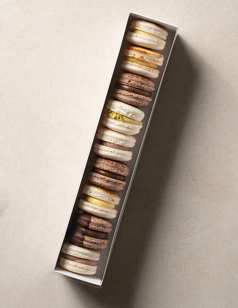 Assorted natural macarons in a gift box with pistachio, chocolate, crème brûlée, mixed berry, and Dubai chocolate flavors from VANIL.