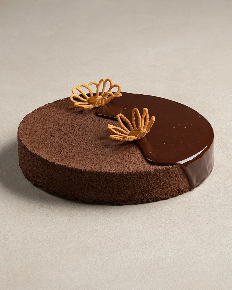 Whole Chocolate Explosion cake with chocolate mousse, chocolate glaze, and salted caramel flower tuile.