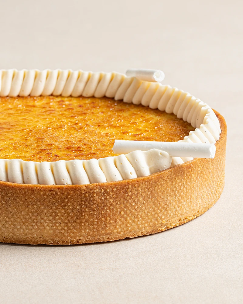 Signature Crème Brûlée with caramelized top, Chantilly cream, and delicate meringue sticks.