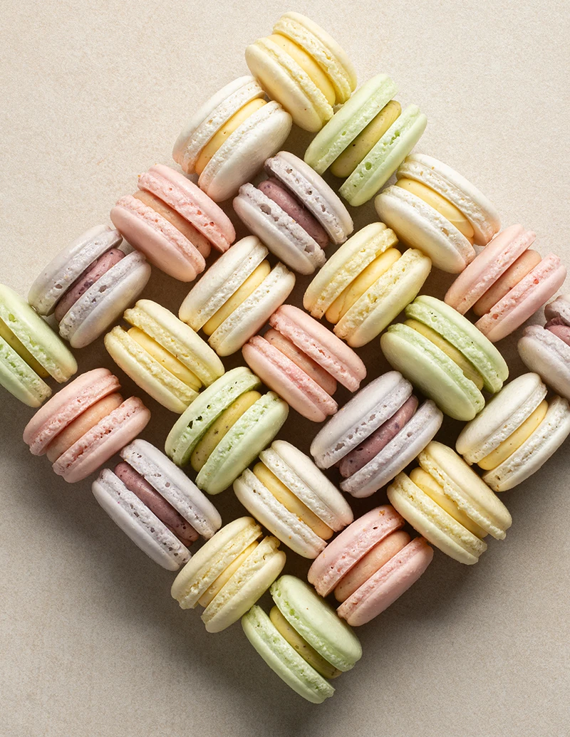 Stack of assorted pastel macarons with delicate shells and creamy fillings.