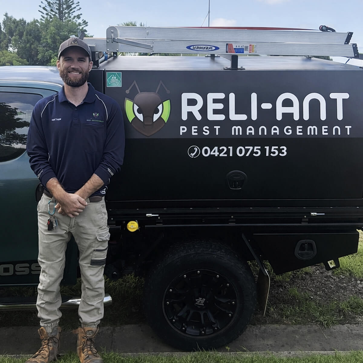 Matthew standing in front of a Reli-Ant Pest Management vehicle