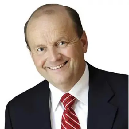 Smiling middle-aged man with balding head wearing a black suit, white shirt, and red striped tie against a white background.