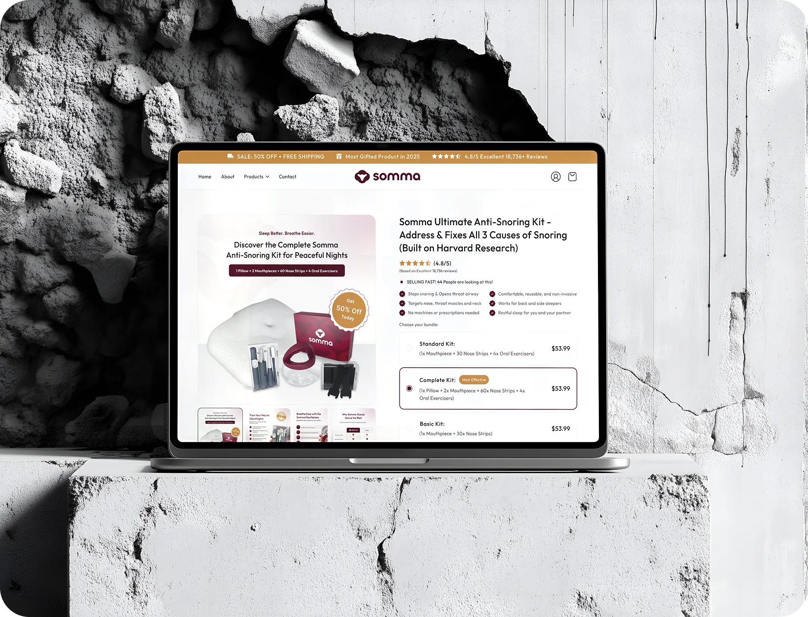 Laptop displaying Somma anti-snoring kit product page with images and pricing options on a textured concrete surface.