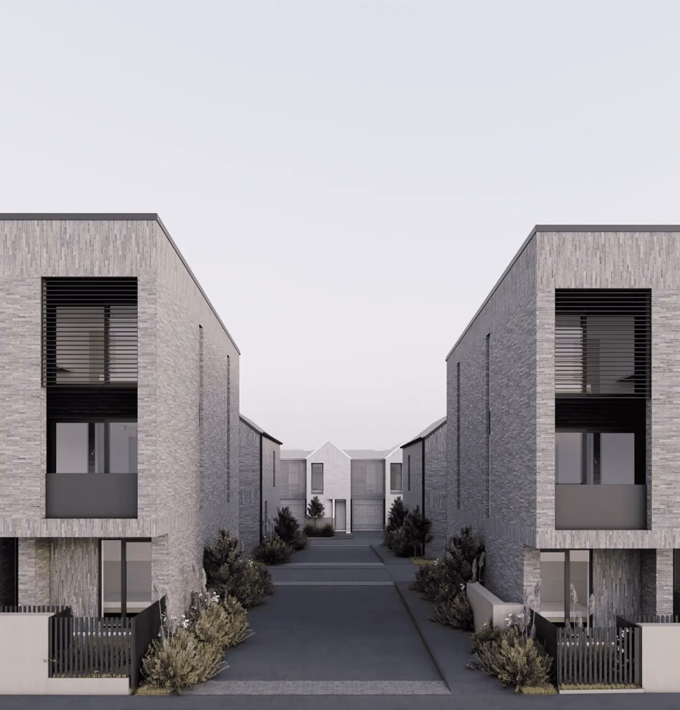 Modern gray brick residential buildings on both sides with a driveway and greenery in between.