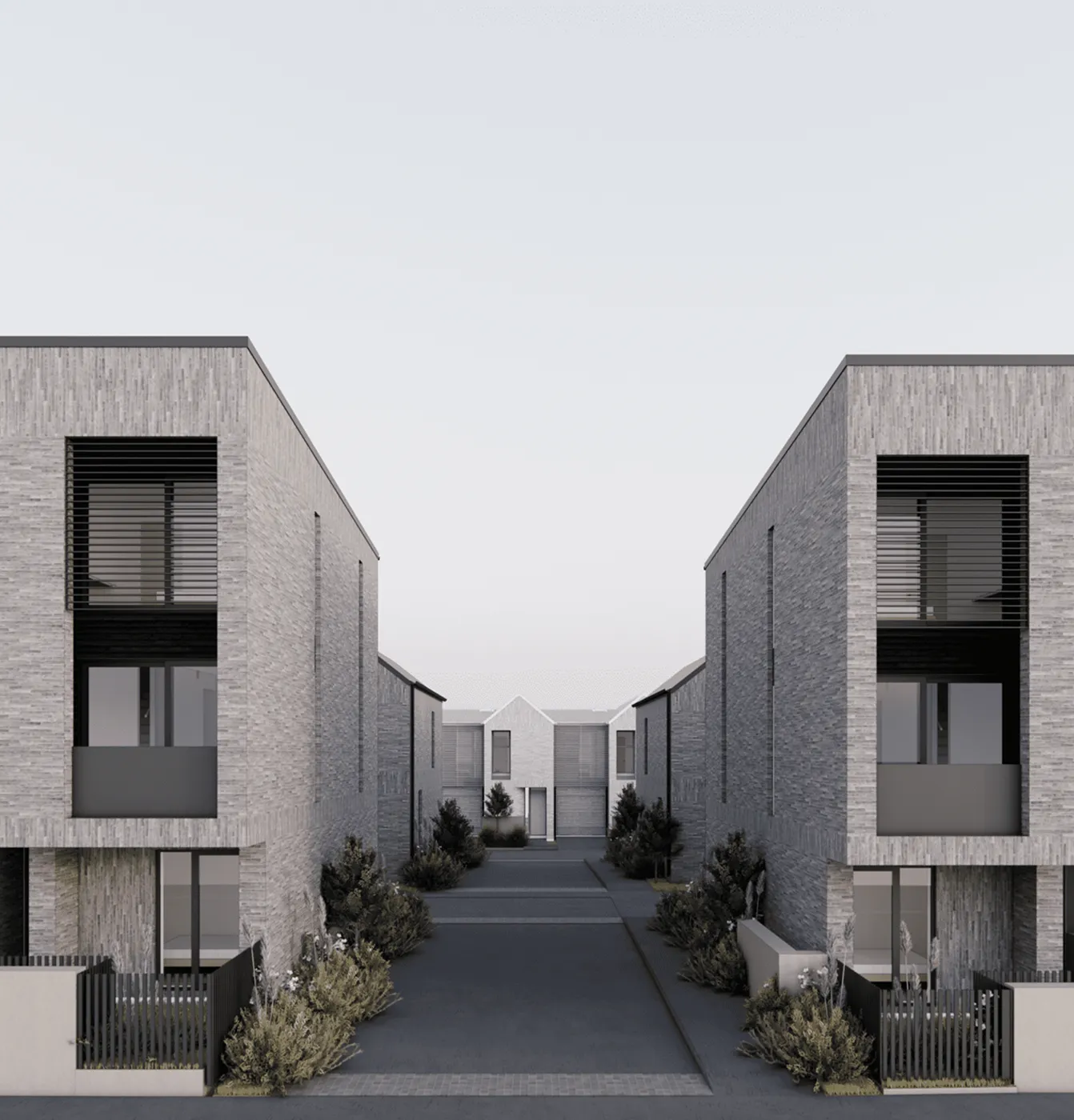Modern gray brick residential buildings on both sides with a driveway and greenery in between.