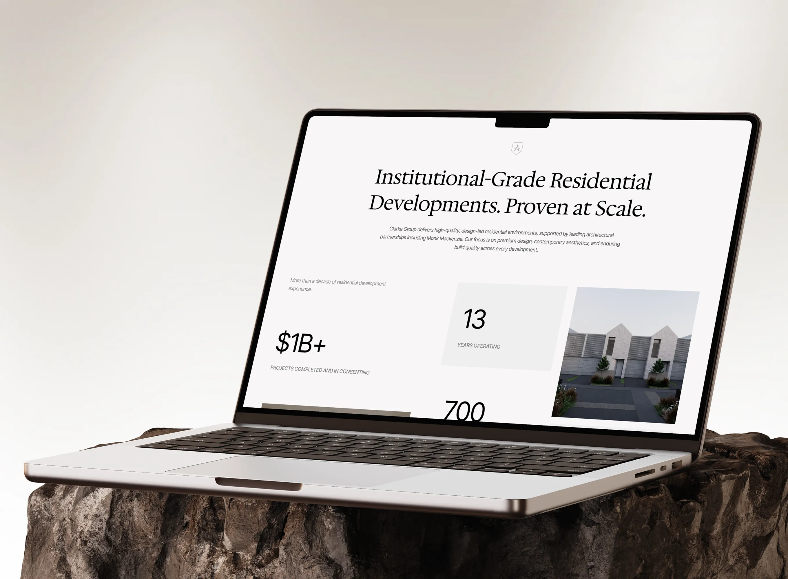 Laptop on rock showing Clarke Group website about large-scale residential development projects.