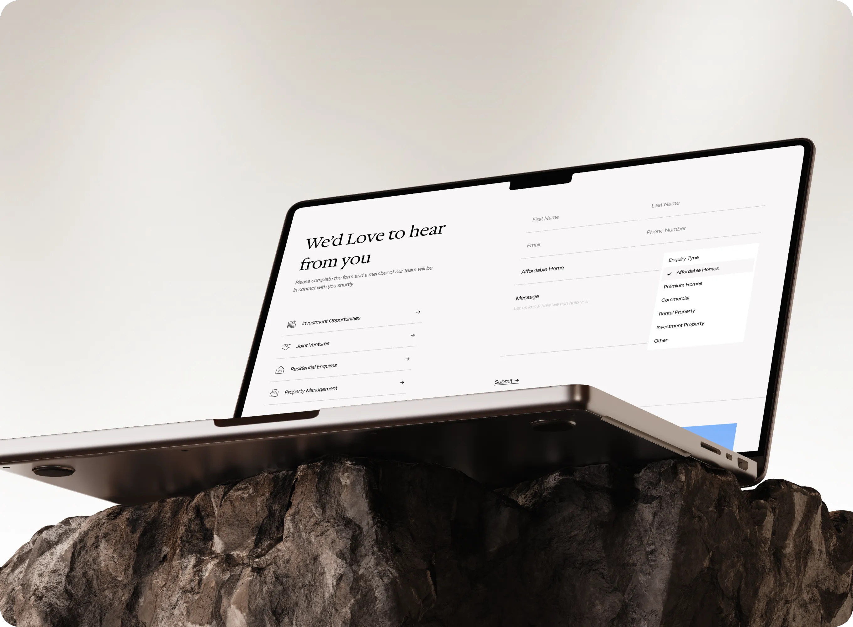 Laptop on rock showing a contact form titled 'We'd Love to hear from you' with fields and enquiry types.