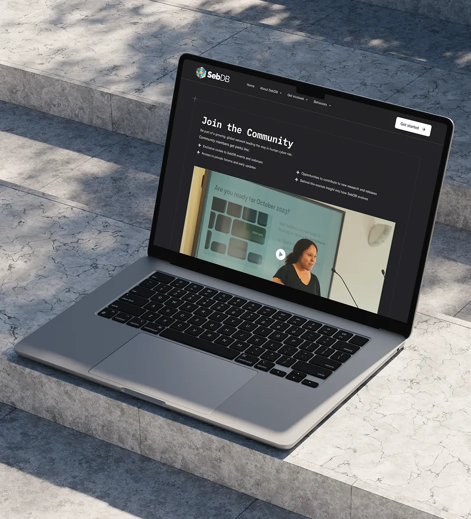 Laptop on stone steps showing SebDB website with Join the Community text and a video thumbnail.