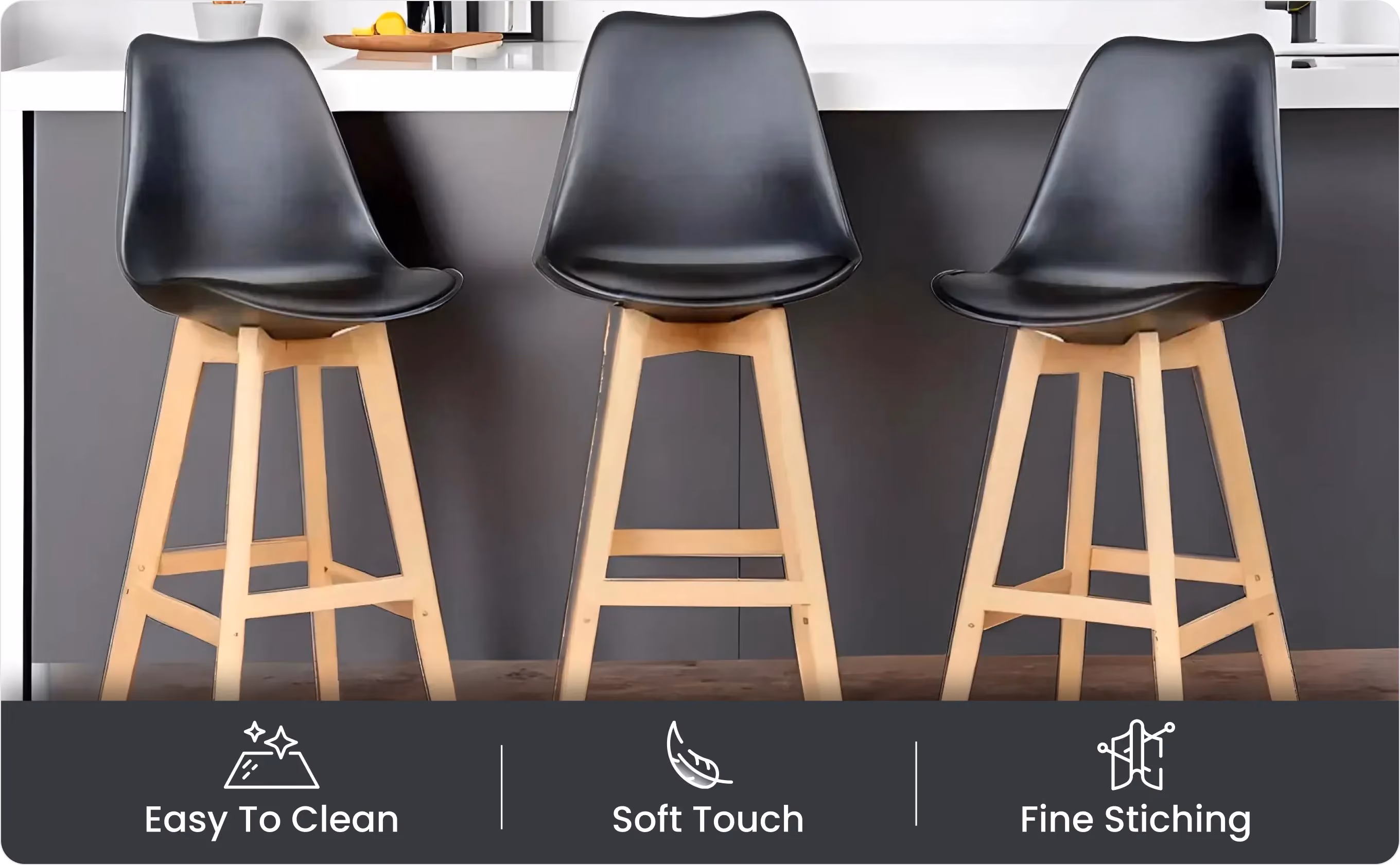 Three black seats with wooden legs in front of a kitchen island with Easy To Clean, Soft Touch, Fine Stitching icons below.