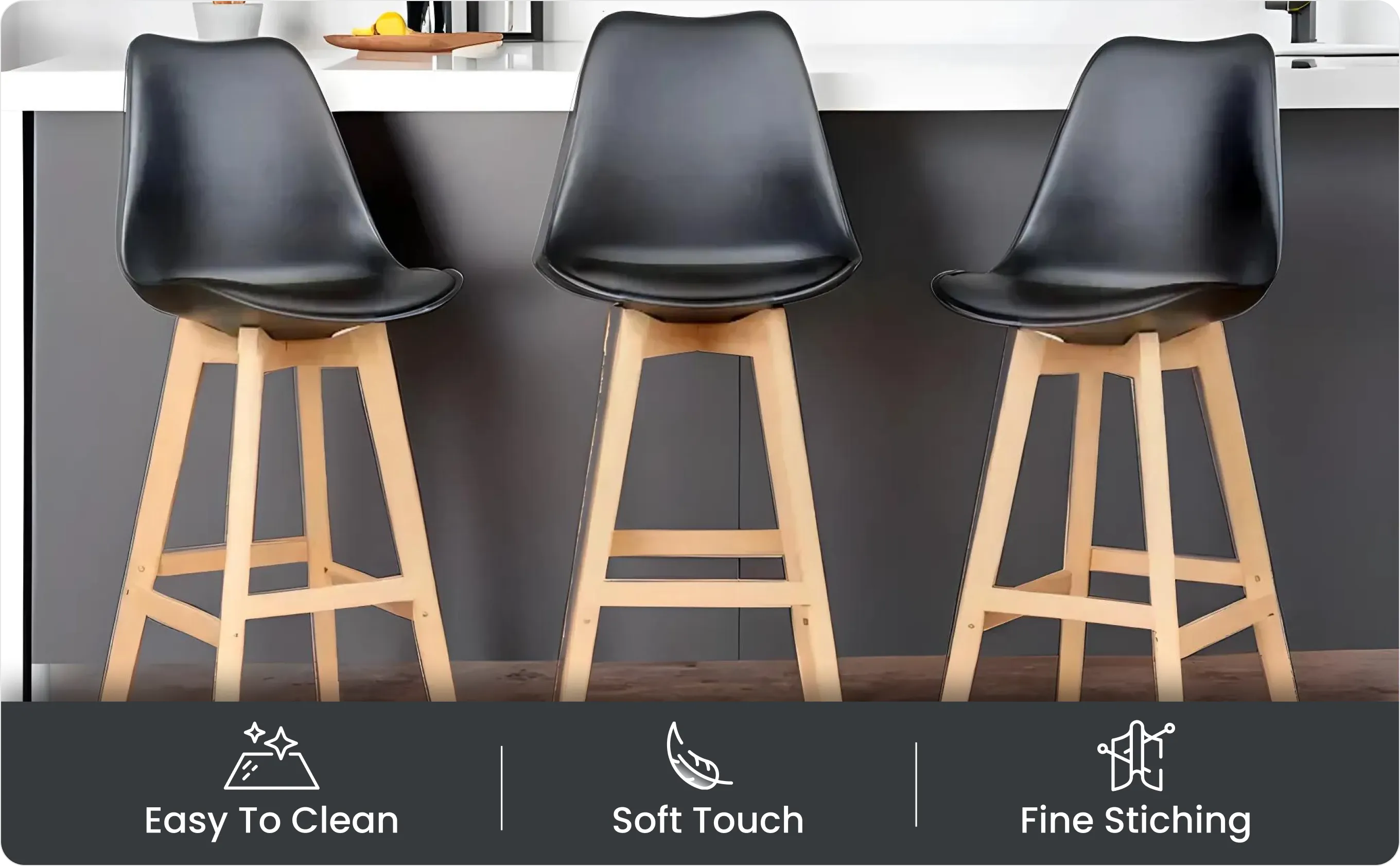 Three black seats with wooden legs in front of a kitchen island with Easy To Clean, Soft Touch, Fine Stitching icons below.