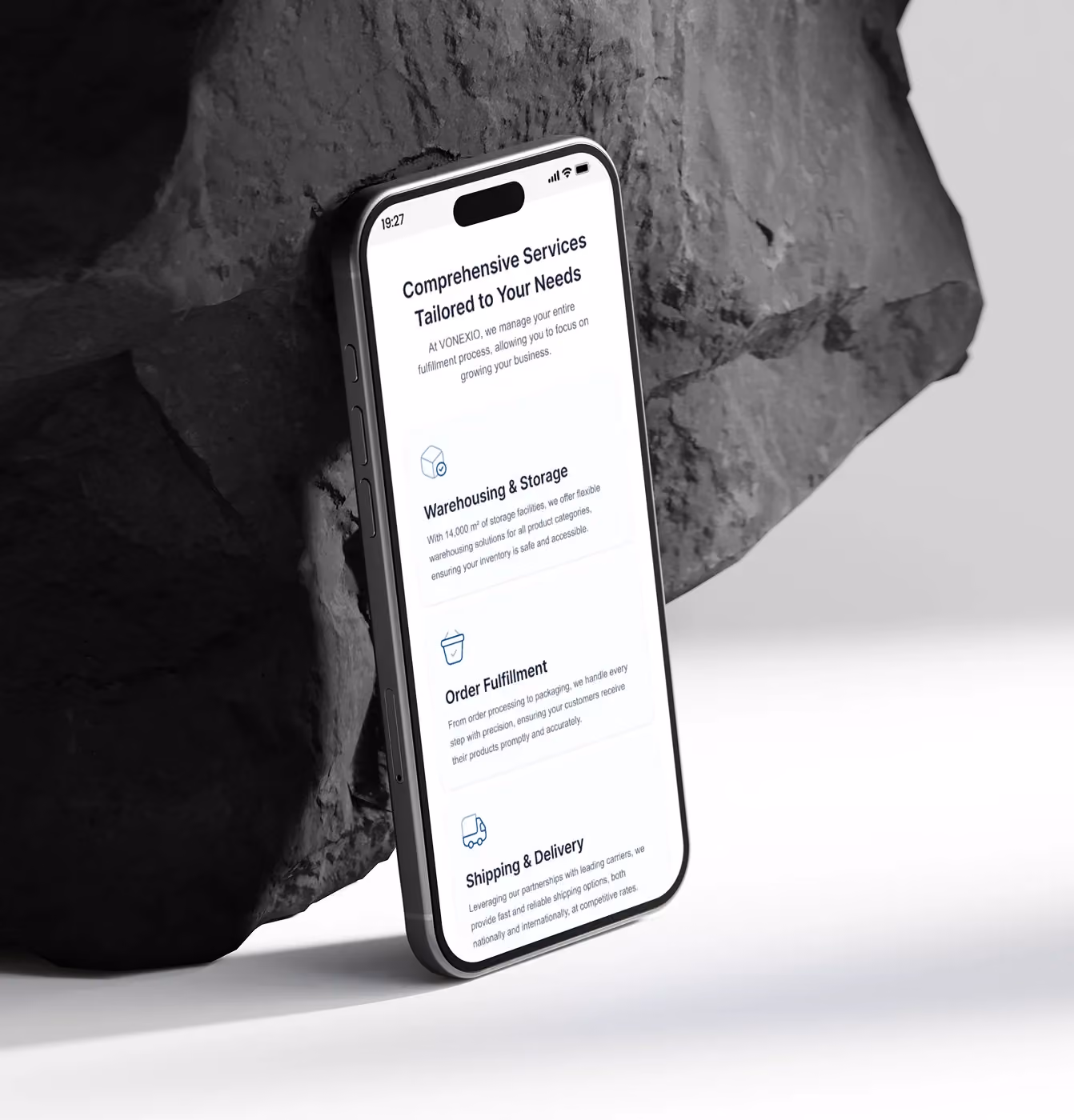 Smartphone leaning against rocks displays comprehensive service info for warehousing, order fulfillment, and delivery.