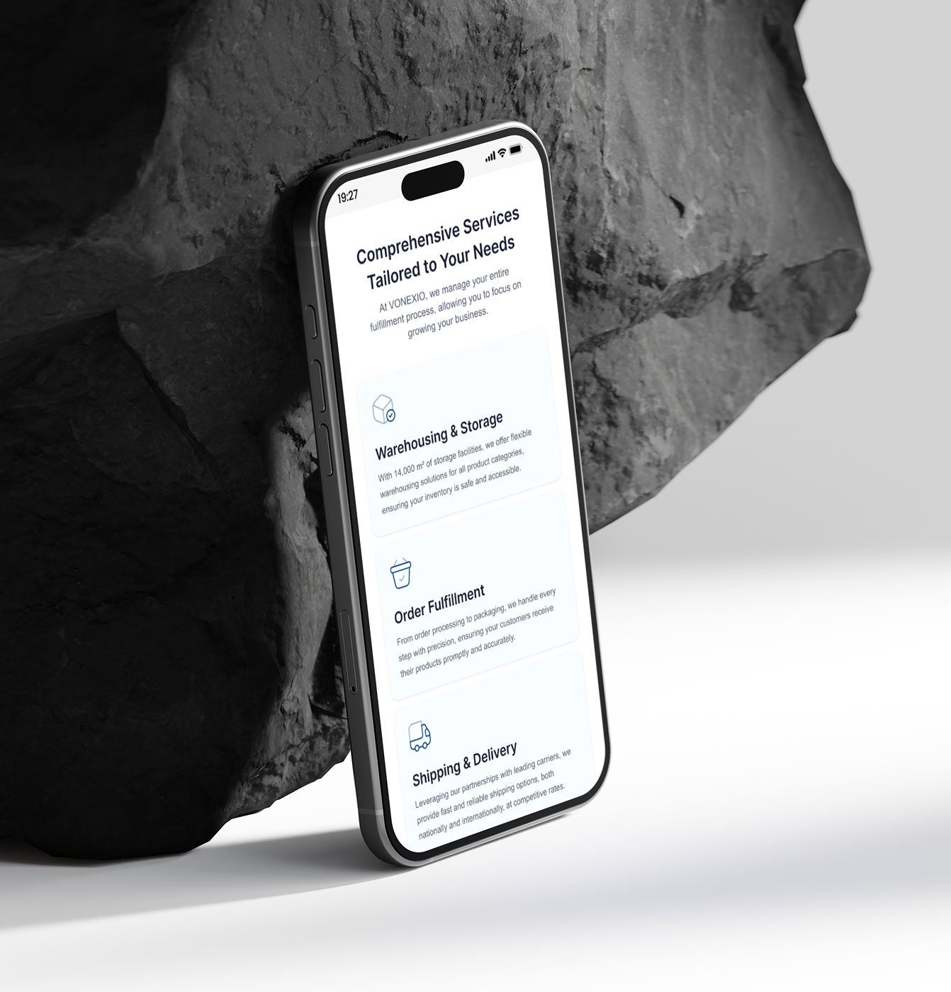 Smartphone leaning against rocks displays comprehensive service info for warehousing, order fulfillment, and delivery.
