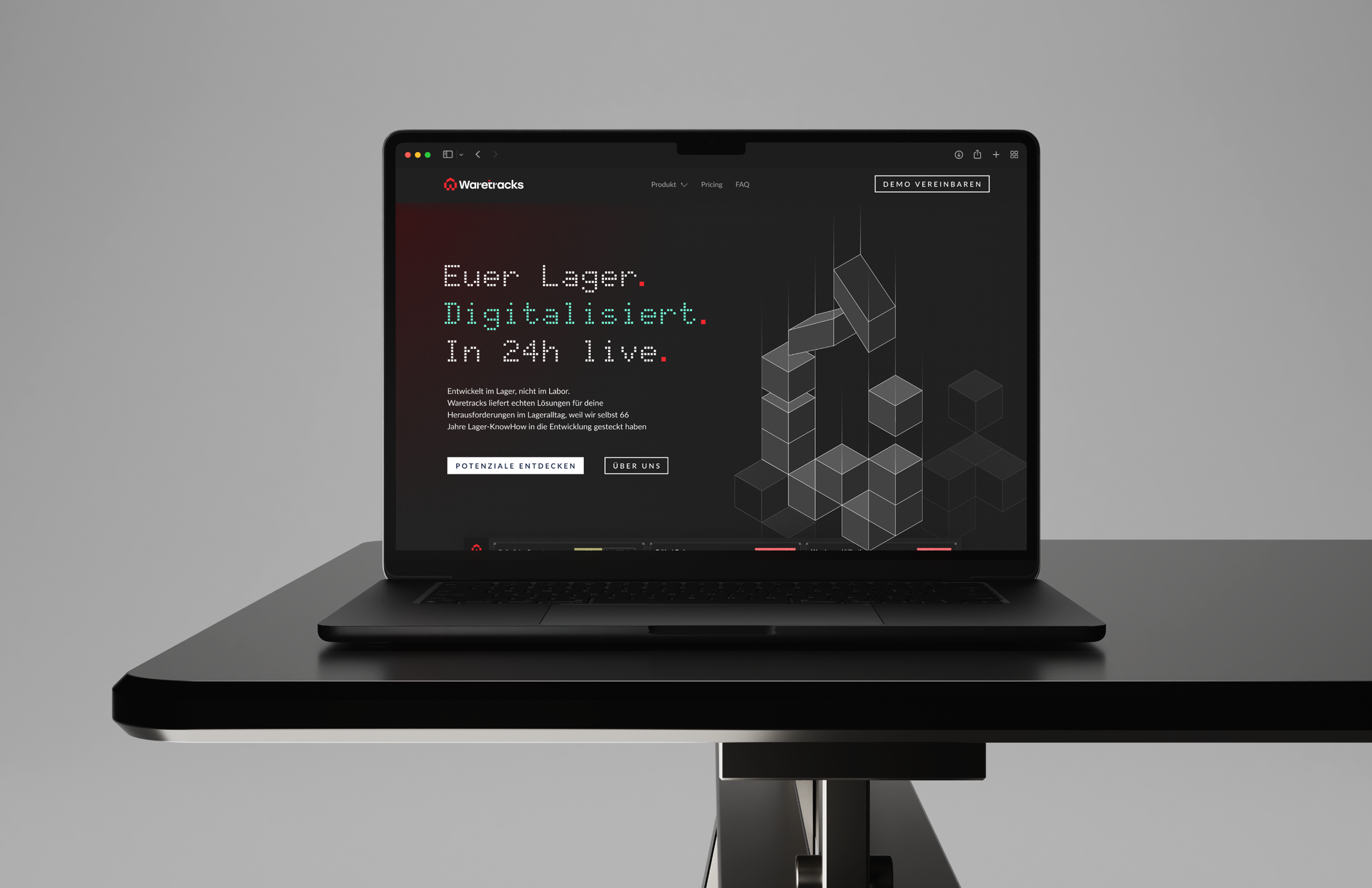 Black laptop on a table displaying Waretracks website with German text and geometric cube graphics.