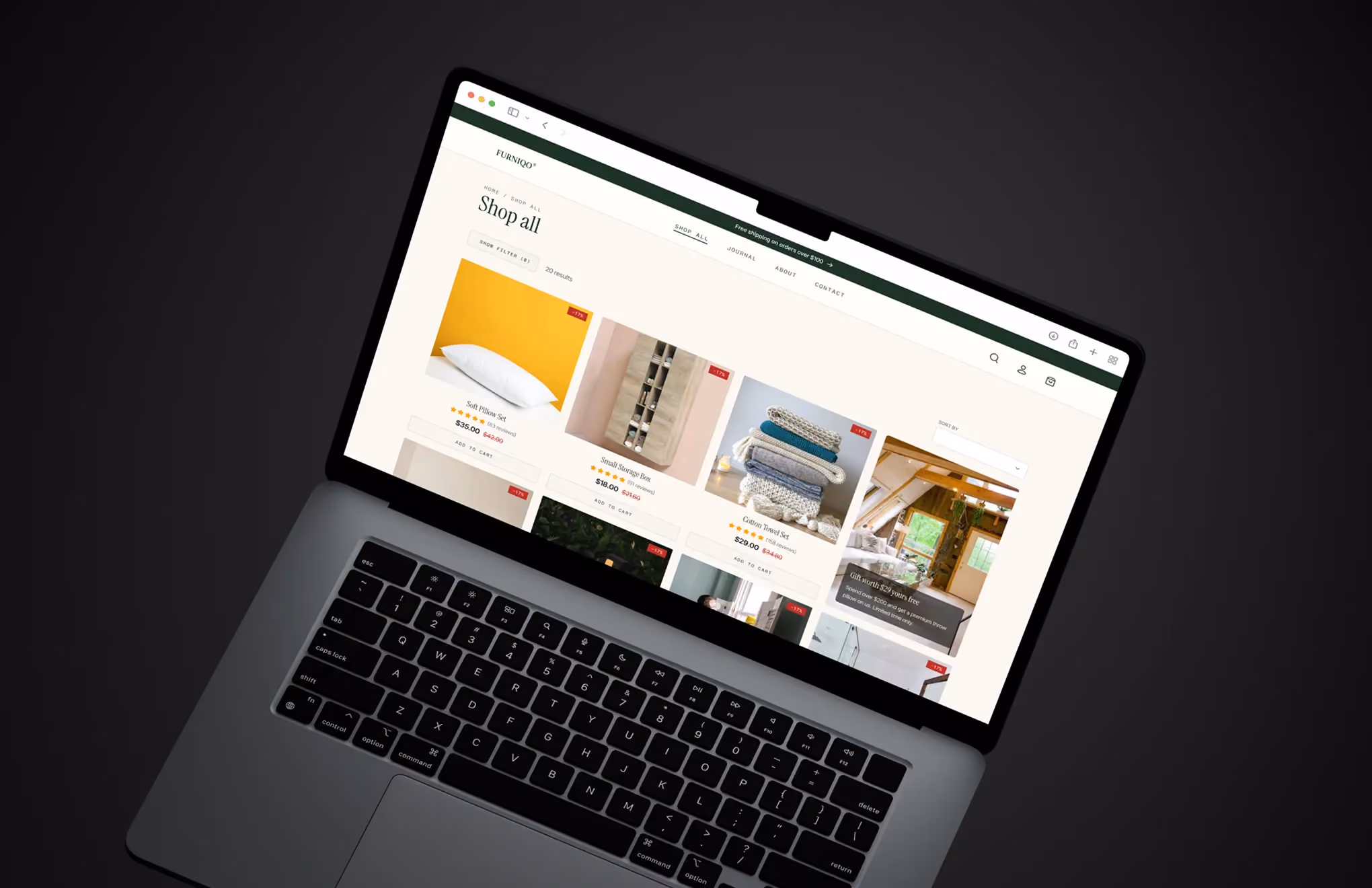 Laptop showing online store page with home decor items like pillows, storage boxes, and towels on sale.