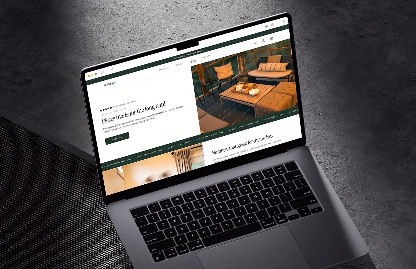 MacBook Pro on textured dark surface showing a furniture website with images and text about quality pieces.