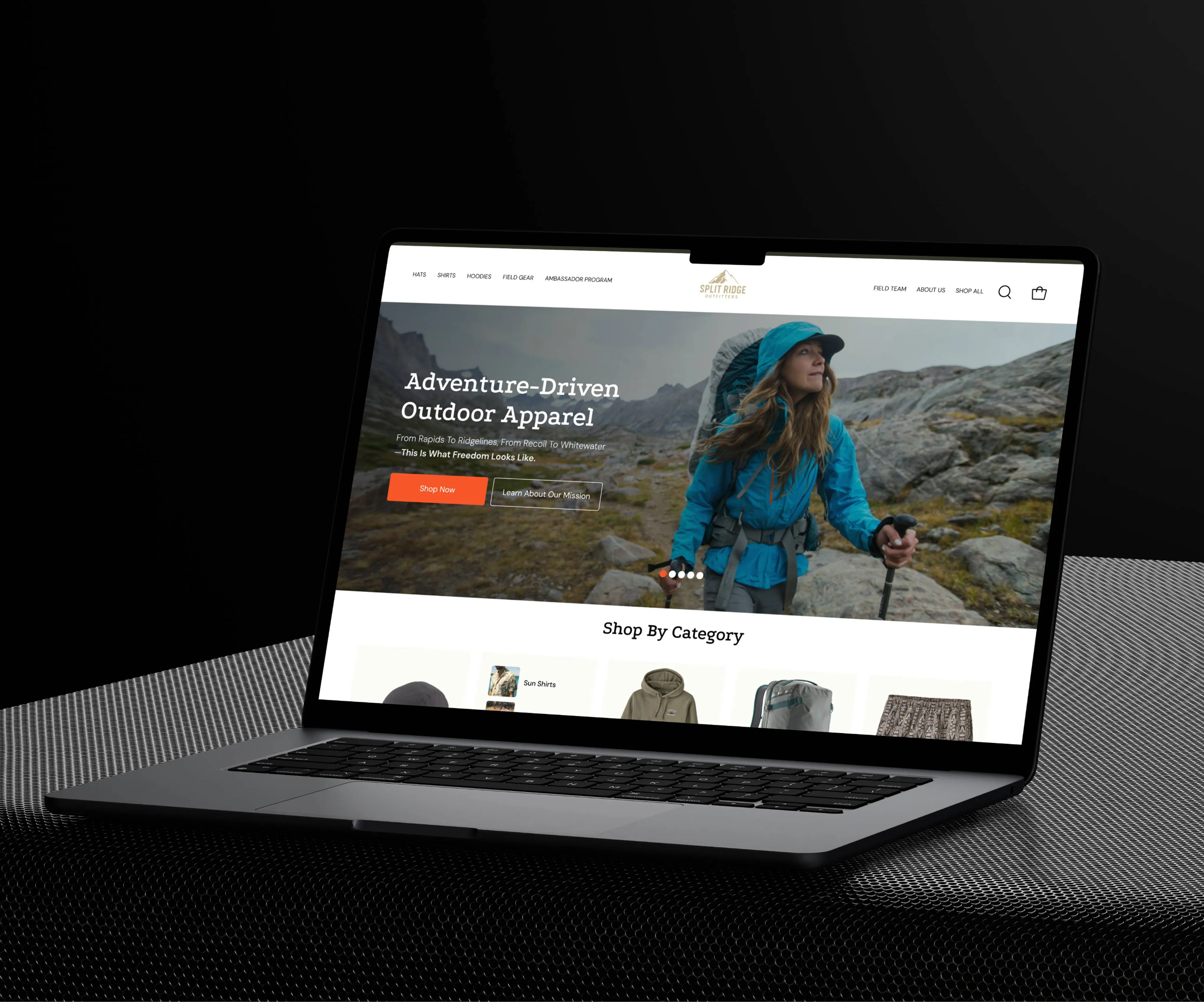 Laptop showing the Split Ridge Outfitters Shopify homepage with the Adventure-Driven Outdoor Apparel hero and Shop By Category row