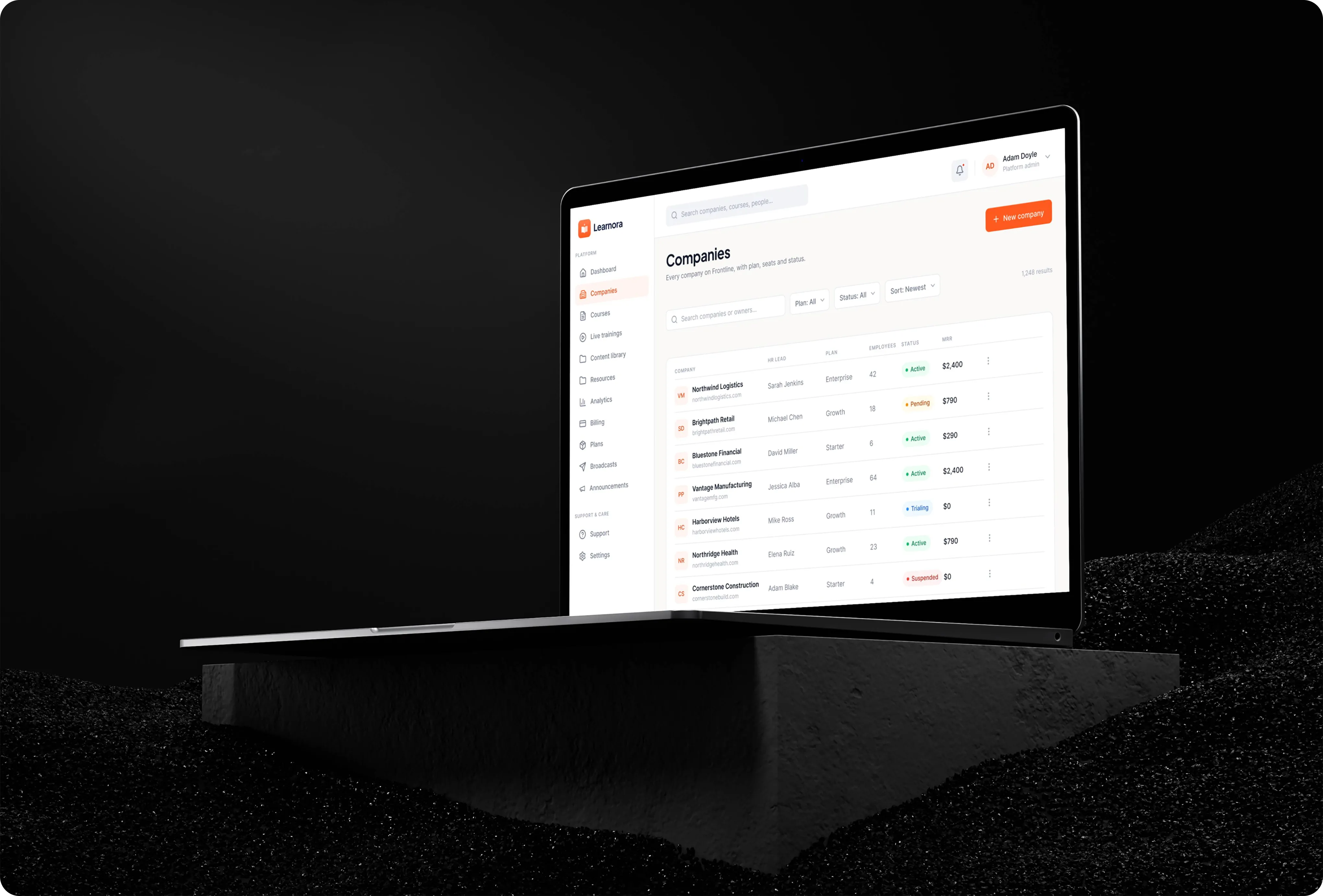 Learnora companies screen on a laptop listing each client company with its HR lead, plan, employees, active, pending, trialing or suspended status and monthly revenue.