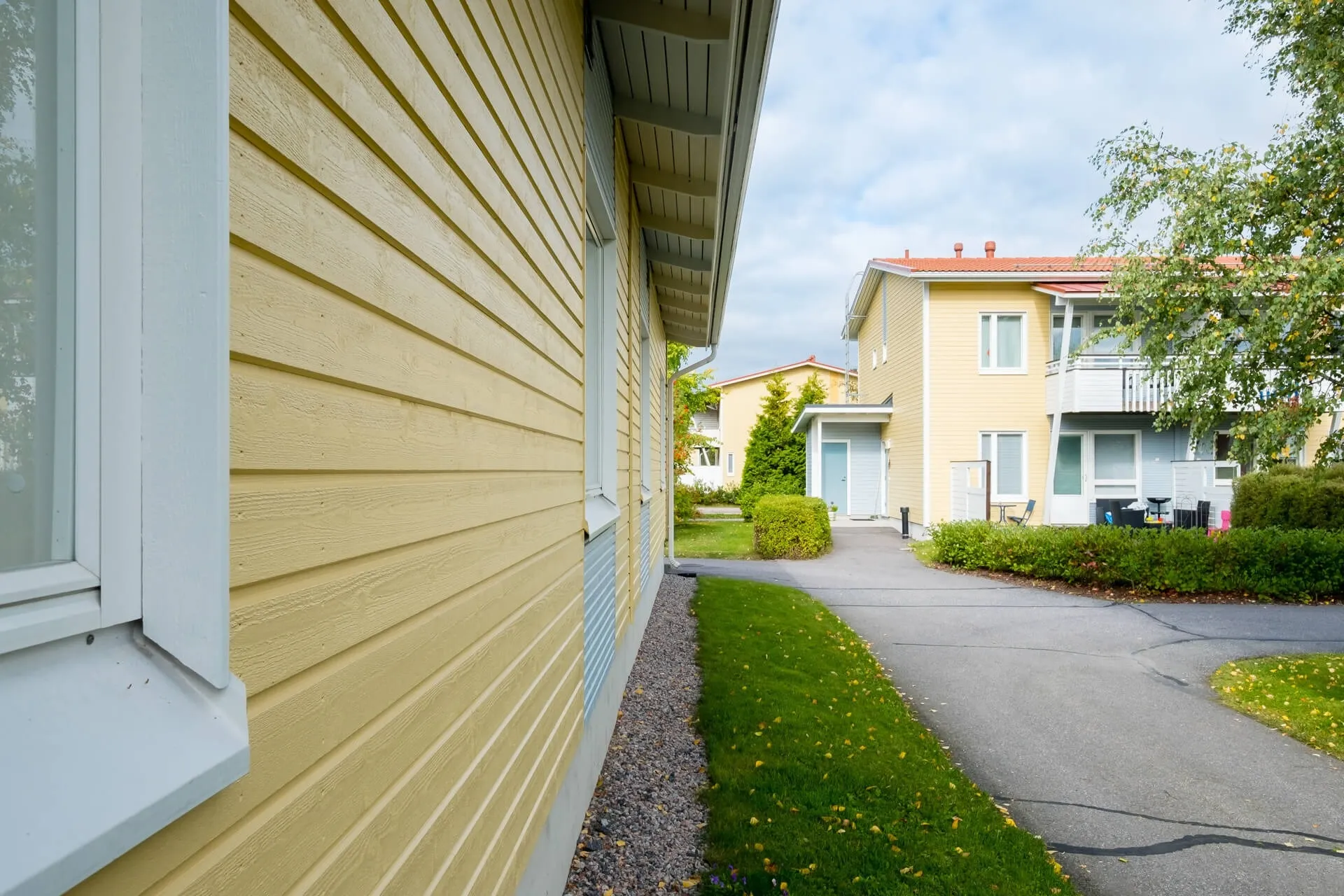 Maalattu vaaleankeltainen puuverhoiltu rakennus