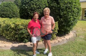 Grace and her friend with tennis rackets in hand.