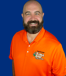Smiling bald man with beard wearing an orange Kanga Roof polo shirt on blue background.