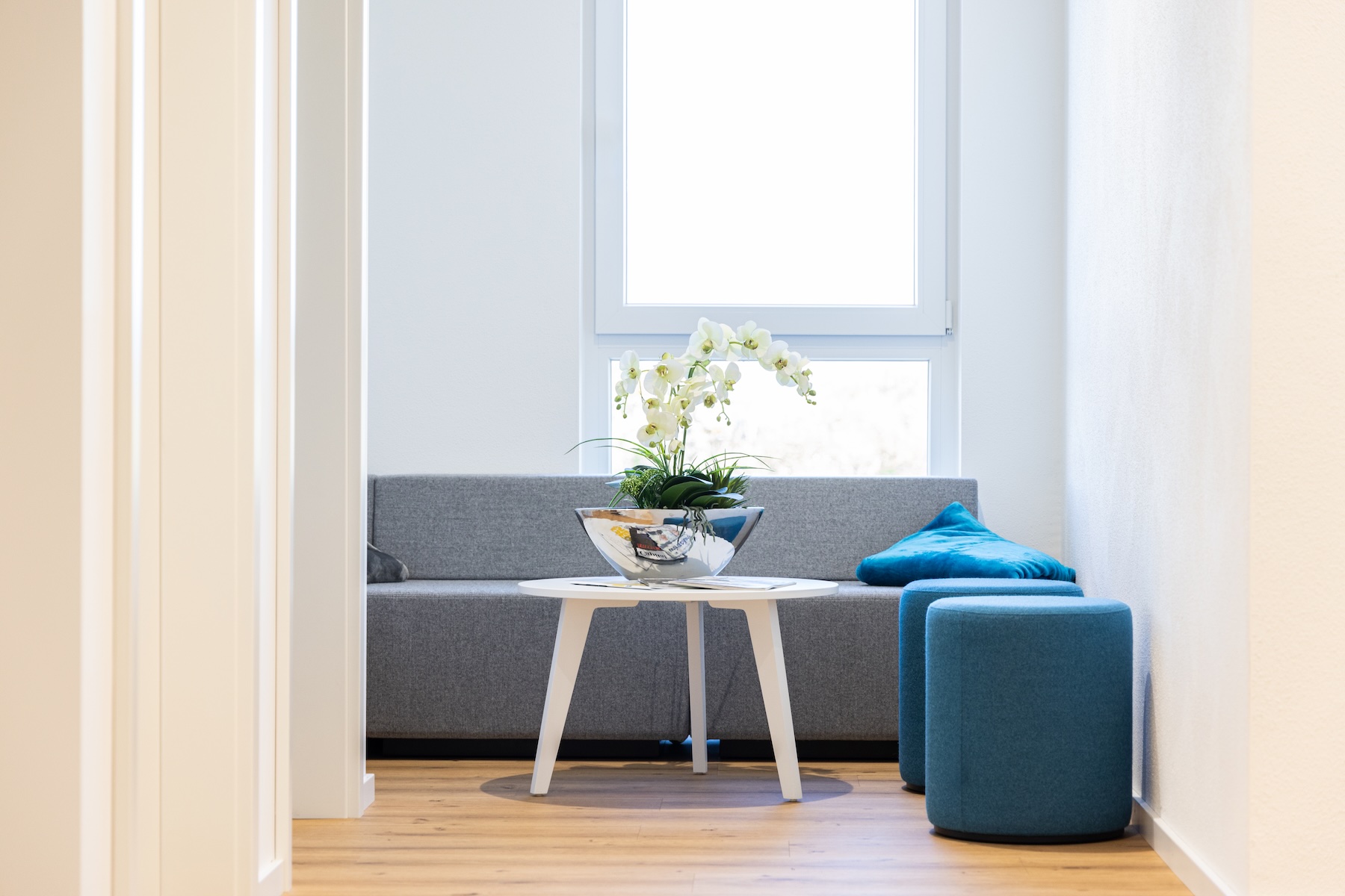 Heller Warte- oder Loungebereich mit Sitzmöbeln am Fenster