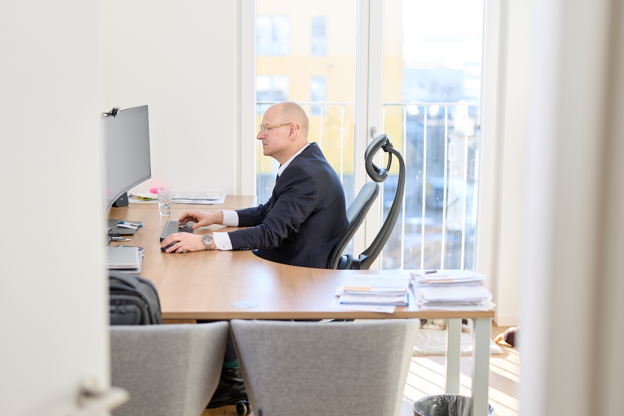 Mann sitzt im hellen Büro an einem Schreibtisch