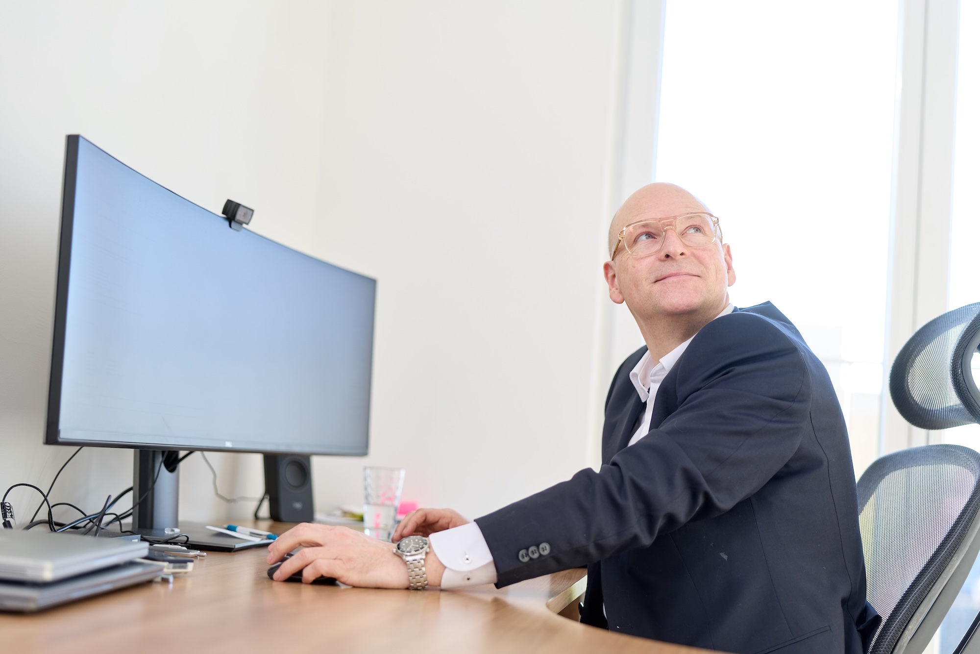 Mann im Büro am Schreibtisch vor großem Monitor