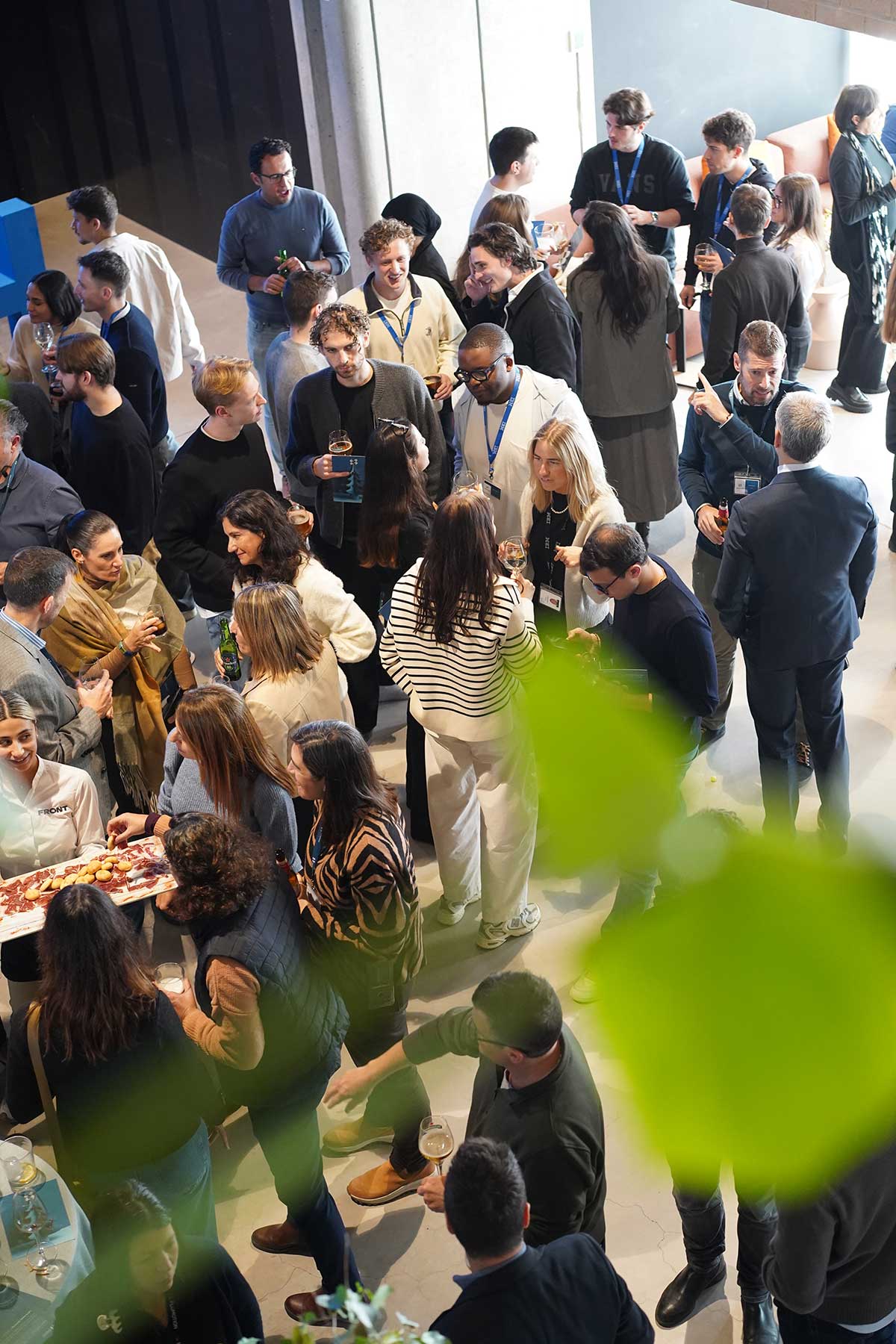 Grupo de personas conversando y disfrutando bebidas en un evento social interior.