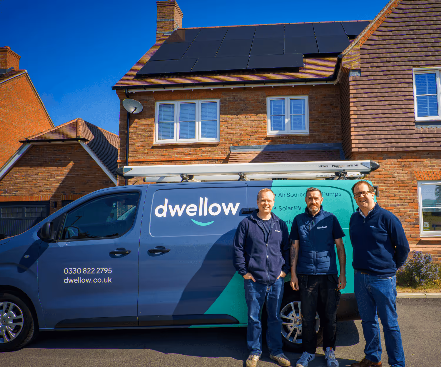 Dwellow team members stood smiling in front of a dwellow branded van.