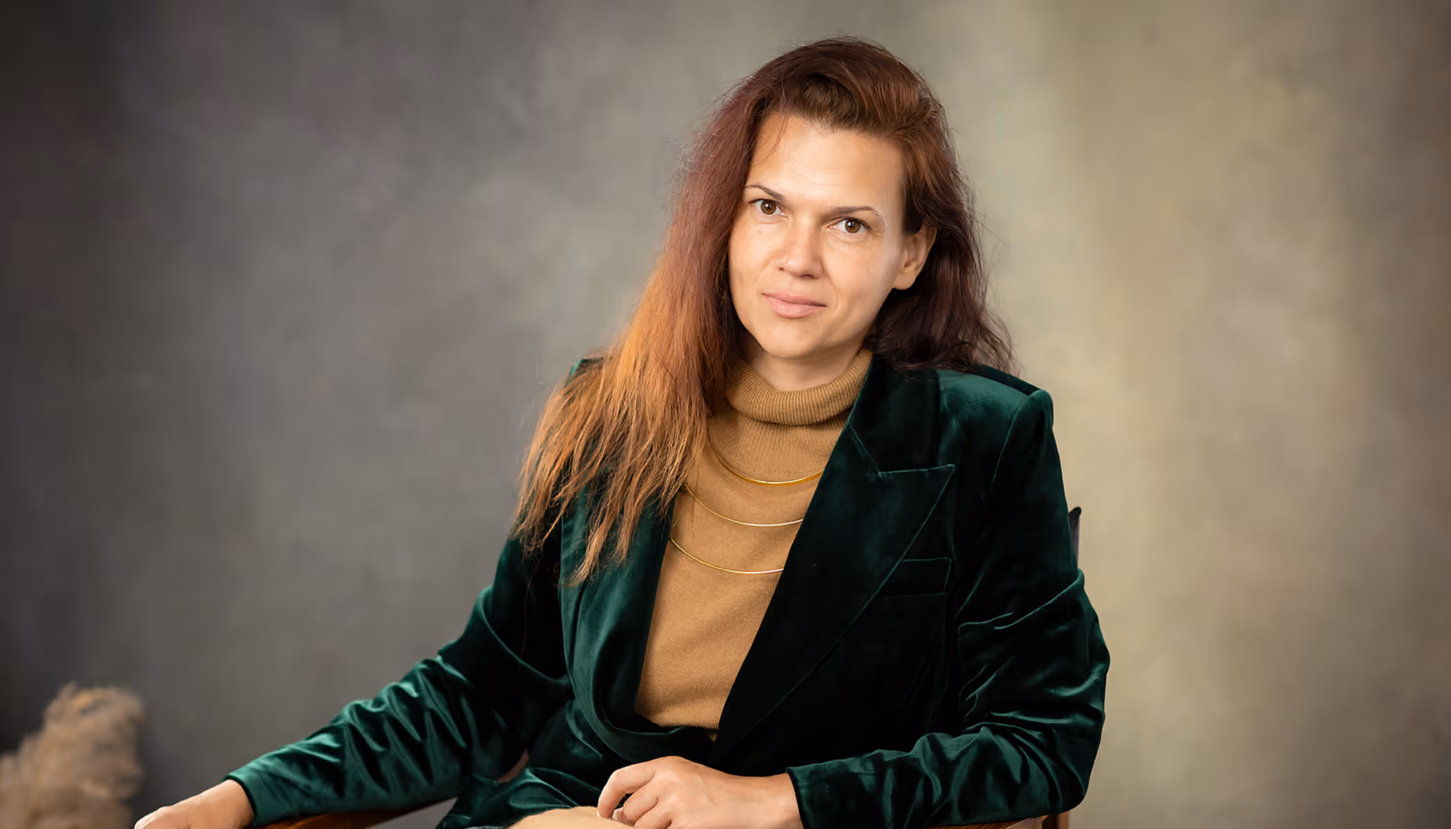 Iryna Burkun Kanta psychologist website hero — portrait of therapist in green velvet jacket