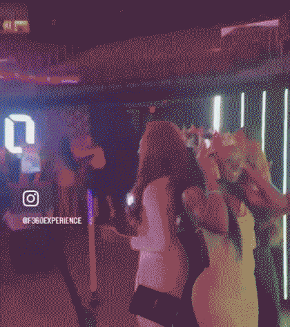 Group of people dancing and enjoying a night out in a dimly lit club with neon lights and a visible Instagram handle @F360EXPERIENCE on the wall.