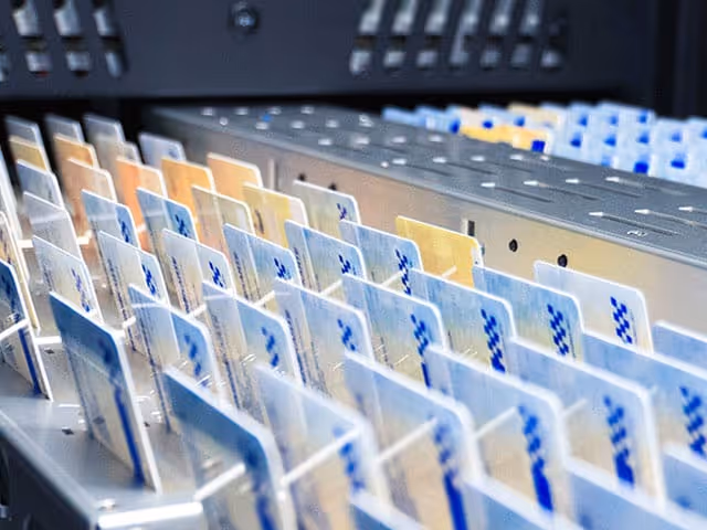 View from inside a car showing a woman driver on an empty road with city skyline ahead and overlay graphics of driver time and route map.