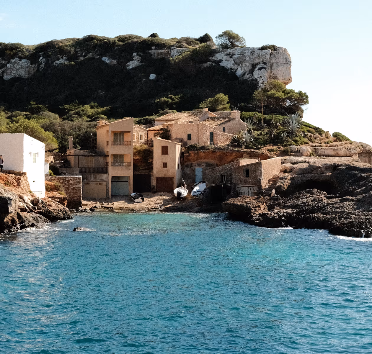 Traditional stone boathouses tucked into a small Mallorcan fishing cove