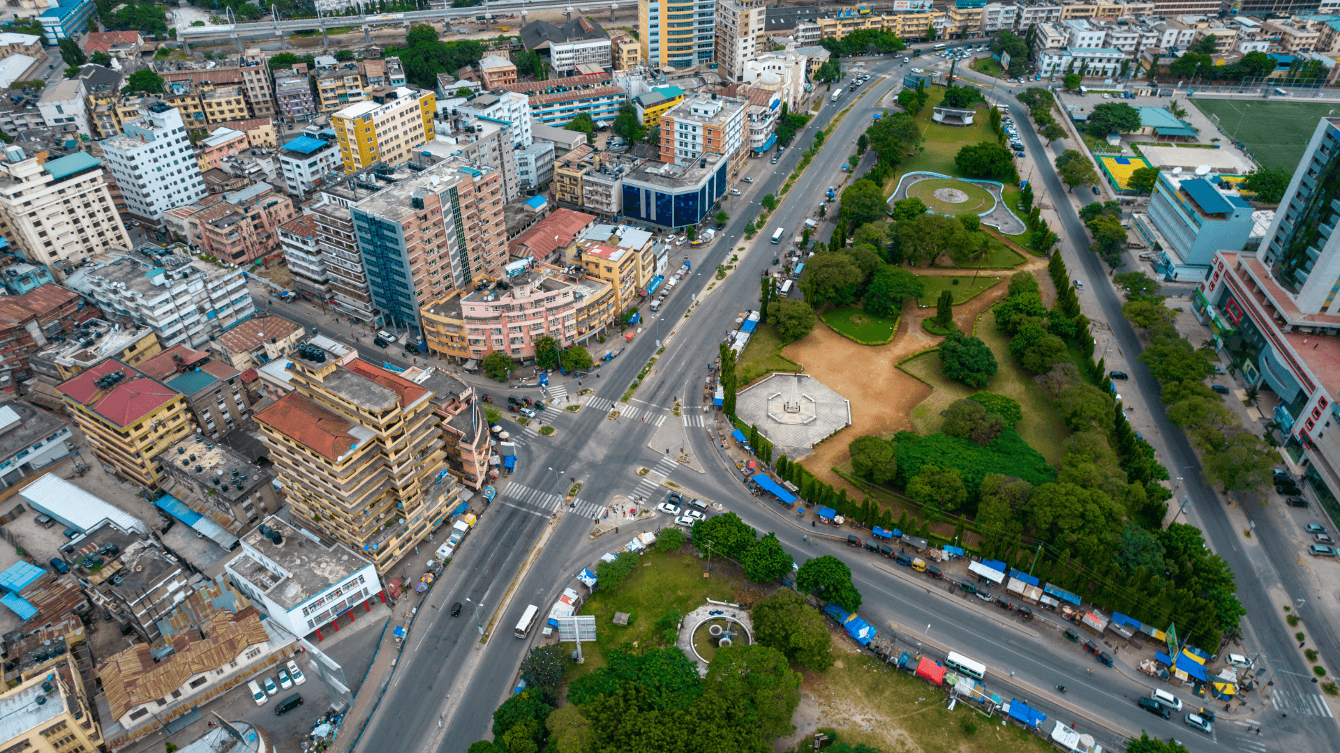 Vue aérienne du centre d'une ville d'Afrique de l'Ouest avec des immeubles, un parc et un grand carrefour