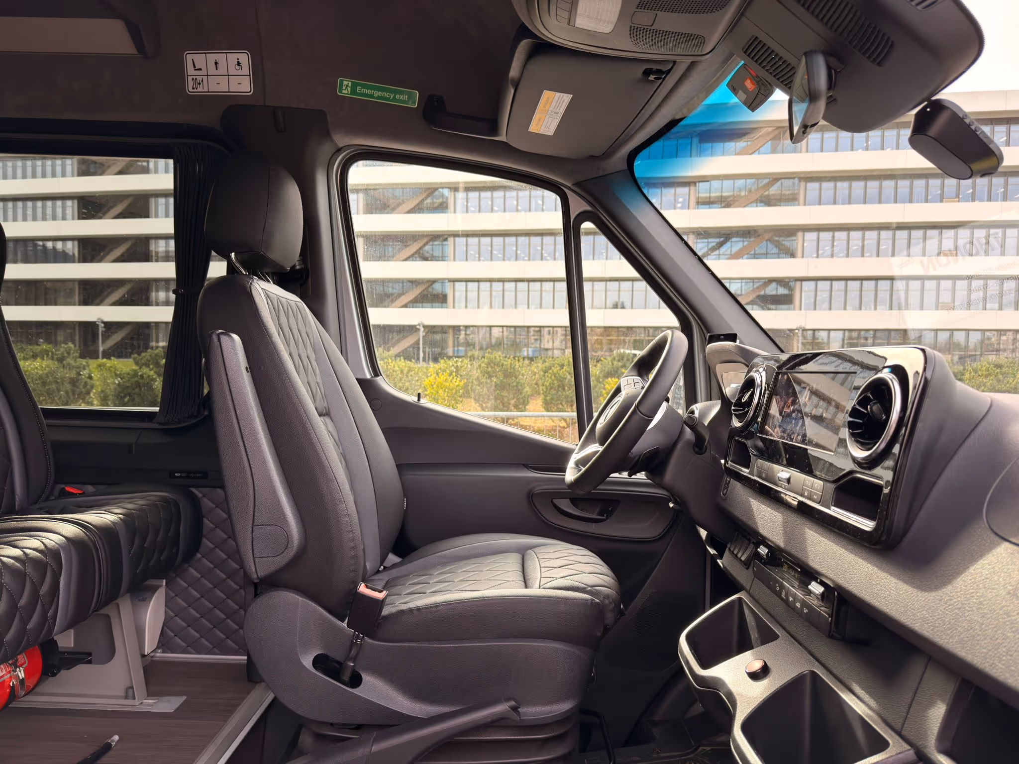 Poste de conduite et siège passager avant d'un minibus Mercedes-Benz Sprinter, affichant un tableau de bord moderne et des finitions haut de gamme.