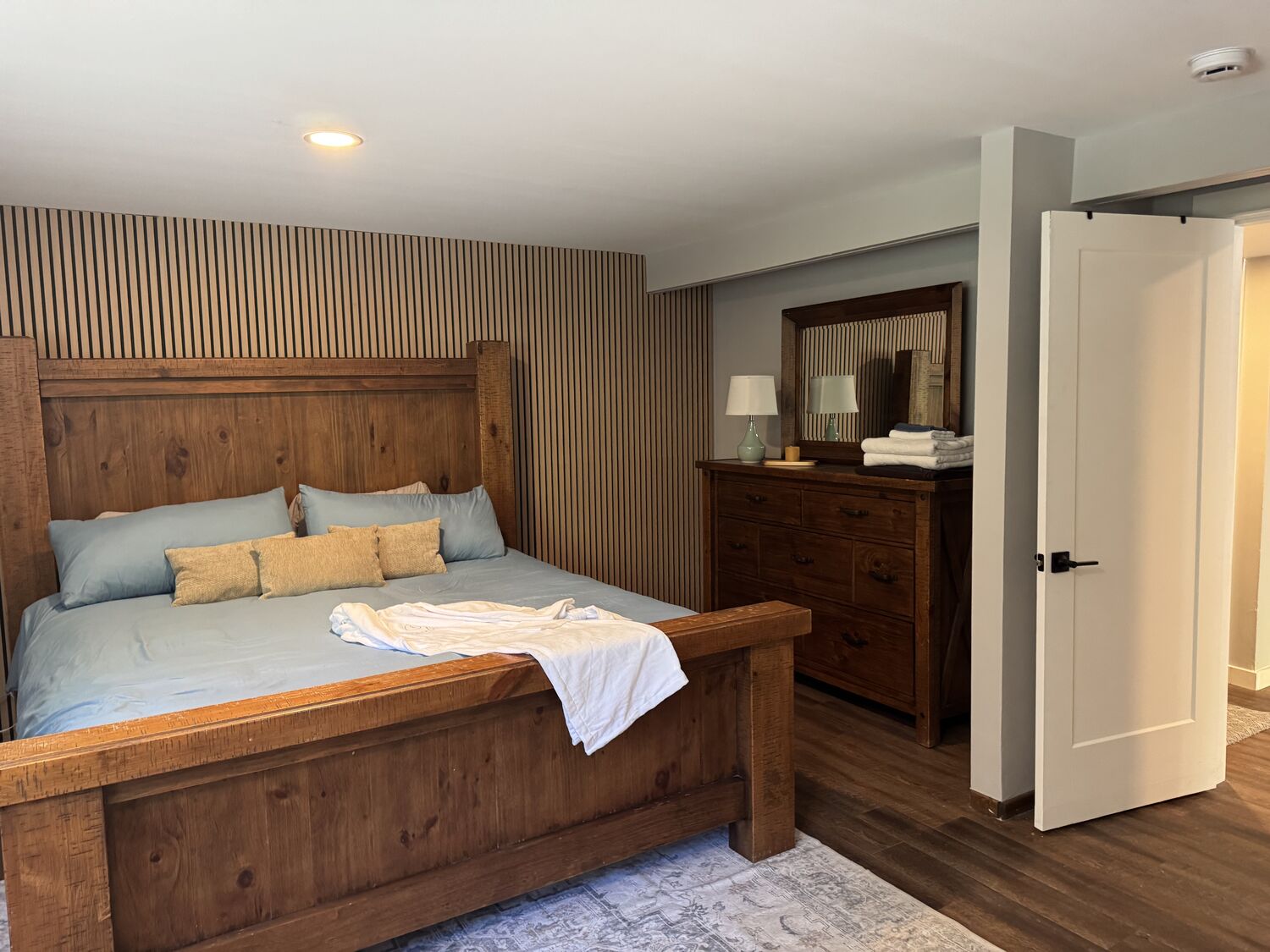 The king bed and slatted feature wall in the King Room walk out at The Healing Oasis
