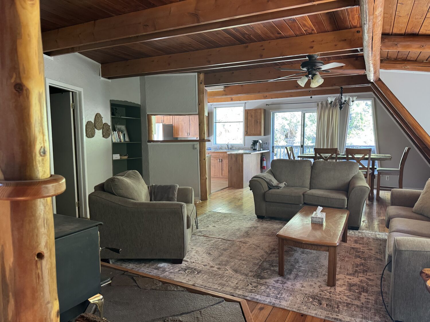 The family room in Eagle Chalet with open wood beams and views out to the trees