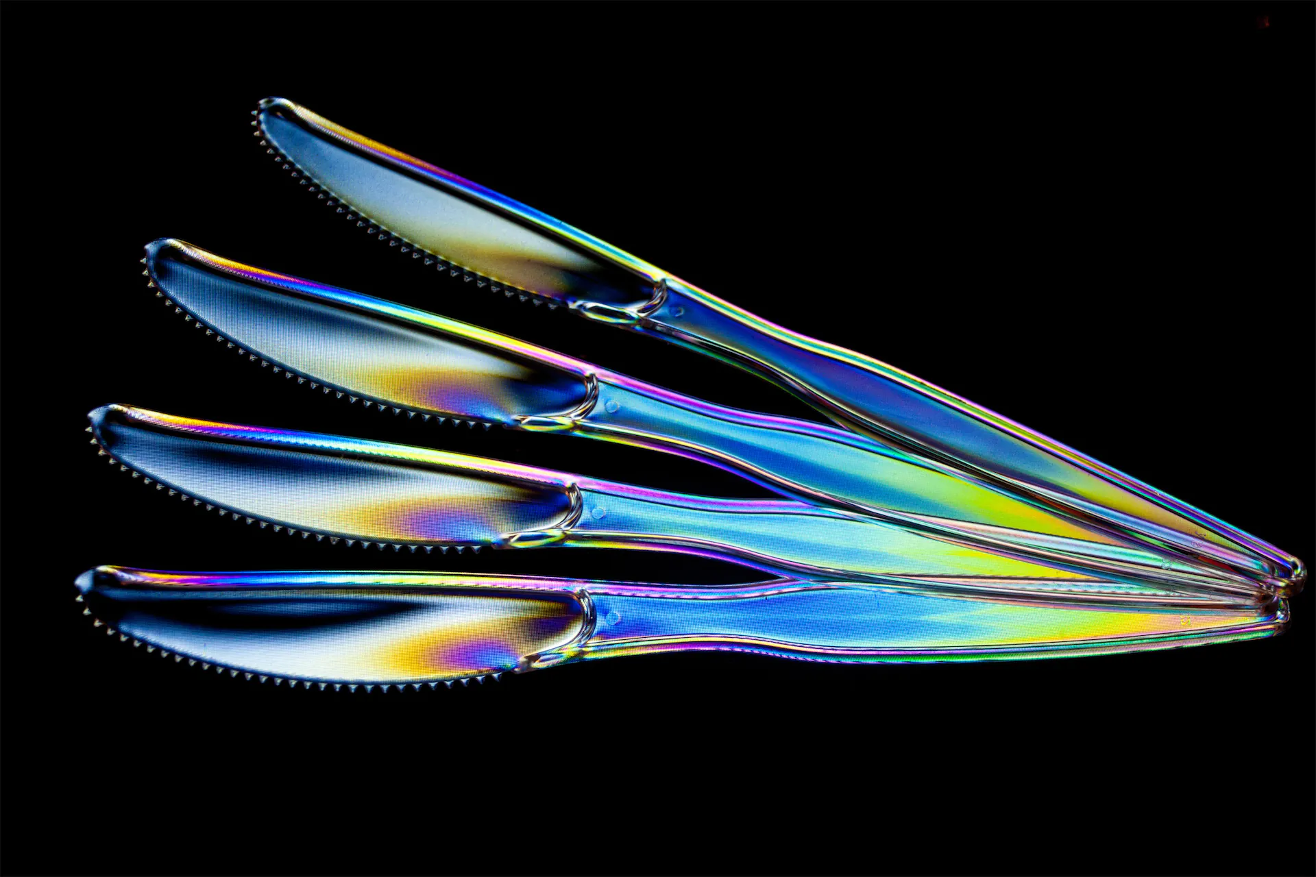 Stylized image of plastic knives with rainbow gradient effect.