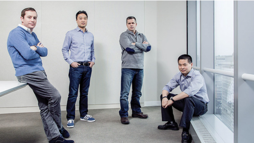 Four men standing in a room looking serious