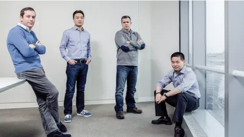 Four men standing in a room looking serious